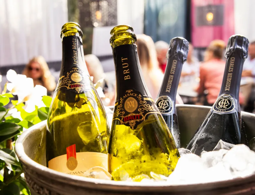 Champagneflaskor på kylning med Indigos uteservering i bakgrunden.