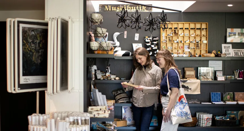 Två kvinnor ser sig omkring i museibutiken vid Ålands kulturhistoriska museum och Ålands konstmuseum.