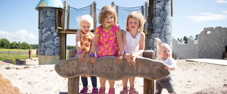 Barn poserar framför attraktion vid familjeparken Smart Park.