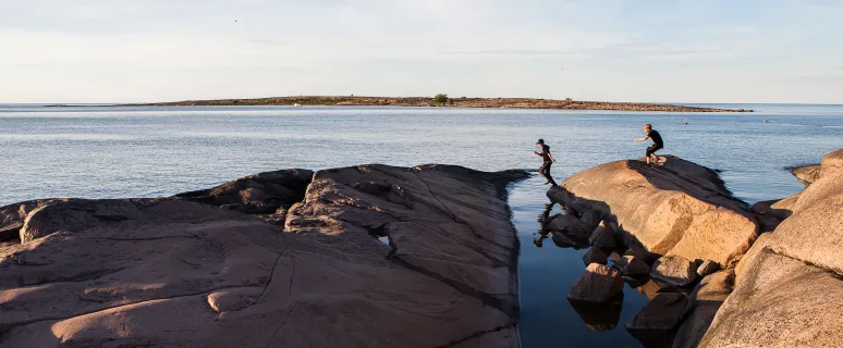 Barn som hoppar på klipporna på Sälskär, Åland.