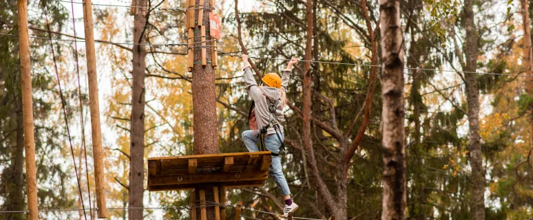 Barn som klättar vid äventyrsbanan Flow Park på hösten.
