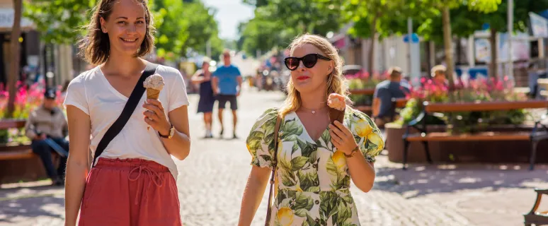 Sommarklädda kvinnor äter glass på gågatan i Mariehamn.