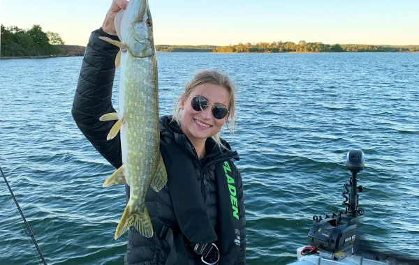 Josefine håller i en nyfångad gädda